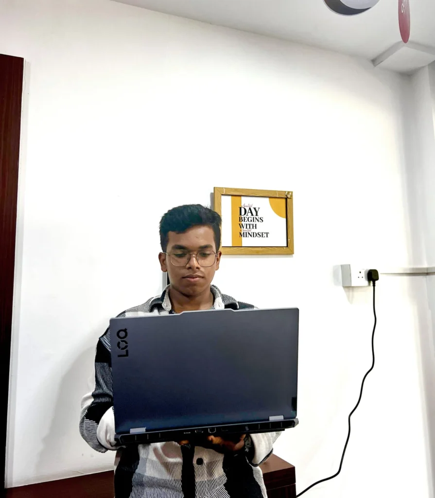 A focused digital marketer working on a laptop in a modern office space, with a motivational quote on the wall.